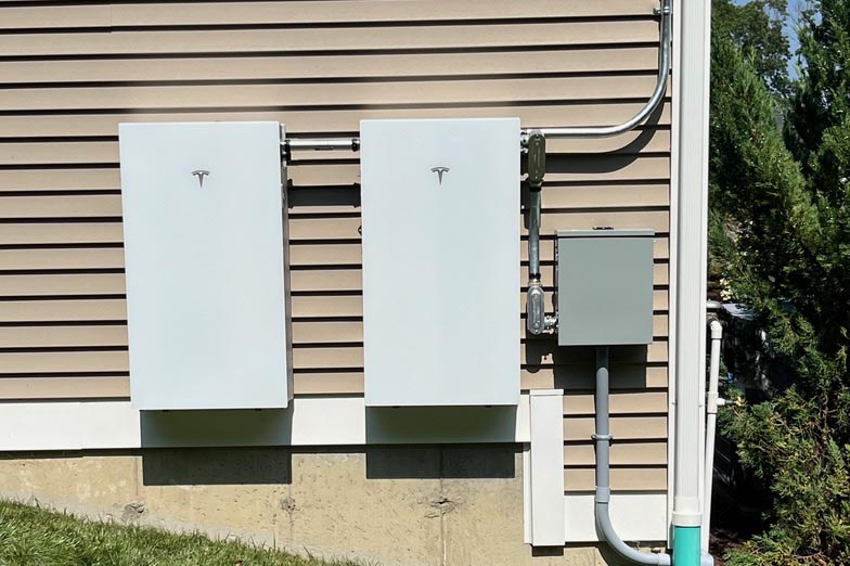 Two Tesla Powerwalls mounted on home exterior